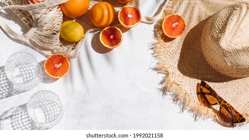 Summer fashion banner flat lay on white background. Holiday party, vacation, travel, tropical concept. Straw hat, sunglasses and citrus fruits. Palm shadow and sunlight, sun. Top view, copy space - Shutterstock ID 1992021158