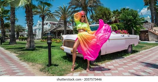 Summer Fashion. Beautiful Sexy Blonde Woman In Colorful Dress Near The Pink Car On Cuba Havana. Spring And Summer Fashion Model Concept. Vintage And Retro Style. Luxury Travel.