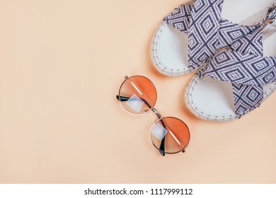 Summer fashion flatlay and gradient round sunglasses   espadrille sandals the beige background  Perfect beach set for holidays the sea  Marina style 