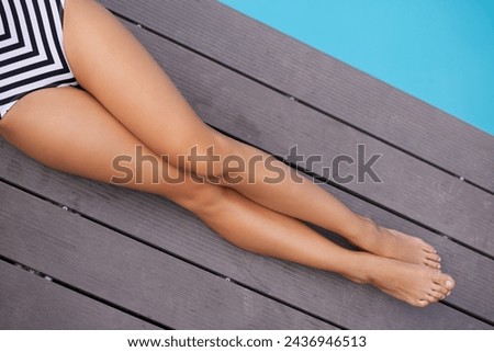 Summer, fashion and legs of woman on deck at pool to relax on luxury holiday or vacation in bikini. Calm, above and person sitting poolside at hotel, villa or outdoor to enjoy water and sunshine