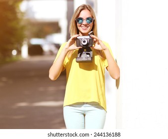 Summer, Fashion And People Concept - Sunny Portrait Smiling Pretty Woman With Old Retro Vintage Camera Having Fun Outdoors