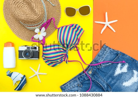 Summer Fashion woman swimsuit Bikini, camera, fish star, sunblock, sun glasses, hat. Travel in the holiday pastel background.  Summer Concept.