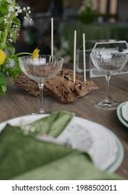 Summer festive table setting. Wedding decoration of the banquet hall. Natural materials. Wooden table, velvet tablecloth. Green color. Soft light. Natural flowers. Plates and glasses. Stylish party