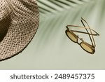 Summer flat lay with straw hat and sunglasses on green background with palm leaf shadow, sun and sunlight. Vacation, holiday, summer creative minimal concept, copy space, banner