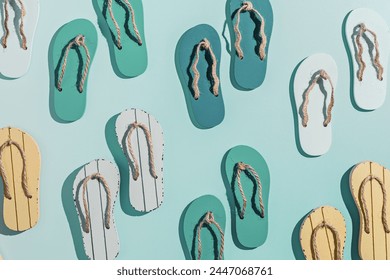 Summer flip flops flat lay, minimal repeat pattern, set of beach footwear vivid colored, top view still life with womans slide sandals, many shoes, summer beach holiday concept, shadow from sunlight