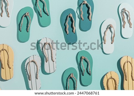 Summer flip flops flat lay, minimal repeat pattern, set of beach footwear vivid colored, top view still life with womans slide sandals, many shoes, summer beach holiday concept, shadow from sunlight