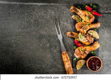 Summer Food. Ideas For Barbecue, Grill Party. Chicken Legs, Wings Grilled, Fried On Fire. With Hot Chili Pepper, Lemon And Bbq Sauce. Dark Stone Table, Copy Space Top View