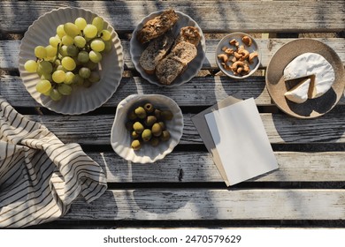 Summer food, picnic. Brie cheese, grapes fruit. Olives, cashew nuts. Bread, baguette. Vintage white wooden table top view. Greeting card, invitation mockup. Copy space, flatlay, delicious appetizers - Powered by Shutterstock