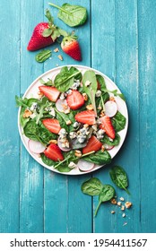 Summer, Fresh Salad With Leafy Greens, Fresh Strawberries, Nuts, Radishes  And Farm Cheese On A Turquoise Wooden Background. Healthy Food Concept