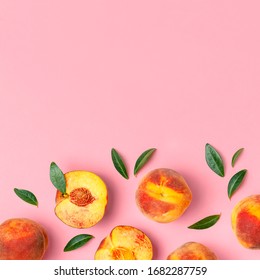 Summer fruit background. Flat lay composition with peaches. Ripe juicy peaches with green leaves on pink background. Flat lay top view copy space. Fresh organic fruit vegan food. Harvest concept