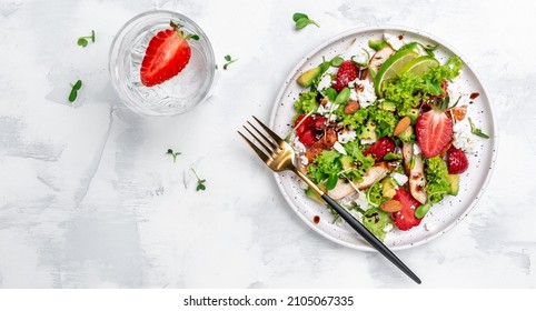 Summer fruit strawberry salad with chicken meat avocado, feta cheese, lettuce and nuts balsamic vinegar, concepts health food.