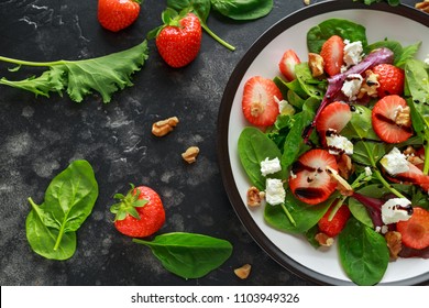Summer Fruit Strawberry, spinach Salad with walnut, feta cheese balsamic vinegar, kale. in a plate. concepts health food - Shutterstock ID 1103949326