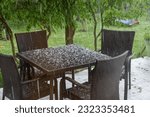 summer furniture on the terrace during a hailstorm in the summer with pieces of ice on the table