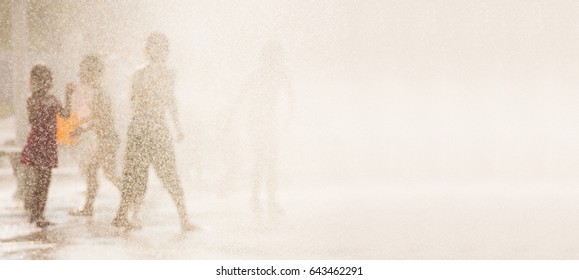 Summer, heat and children playing in the streams of water from the fountain in the city - Powered by Shutterstock