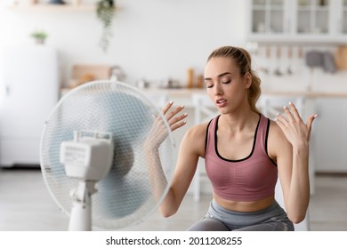 Summer Heat, Workout At Home, Breathe Fresh Air From Floor Fan, Suffering From Lack Of Conditioner. Tired Millennial Blond Lady Use Ventilator Struggle With Summer Hot Weather After Workout Indoor