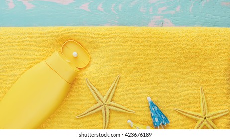 Summer holiday background with sea shells and suntan lotion on beach towel. Top view,  blank space