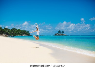 Summer And Holiday Concept - Laughing Woman Jumping On The Beach