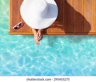 Férias de verão conceito de moda - bronzeamento mulher vestindo chapéu de sol em uma vista cais de madeira de cima