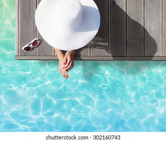 Summer Holiday Fashion Concept - Tanning Woman Wearing Sun Hat On A Wooden Pier View From Above