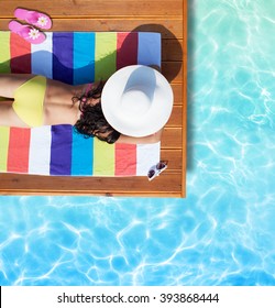 Summer Holiday Fashion Concept - Tanning Woman Wearing Sun Hat On A Wooden Pier View From Above