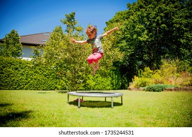 Summer holiday, sport, rest, happy childhood concept. Little cute child girl having fun outdoors and she jumping on a trampoline. Horizontal image.
 - Powered by Shutterstock