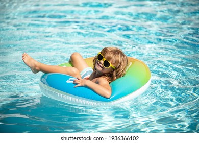 Summer holiday. Summertime kids weekend. Child in swiming pool. Funny boy on inflatable rubber circle at aquapark