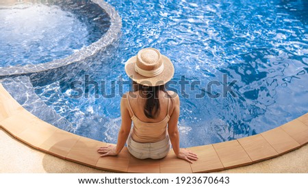 Summer holiday Young asian Beautiful woman relaxing in swimming pool at spa resort. Beautiful tropical beach front hotel resort with swimming pool