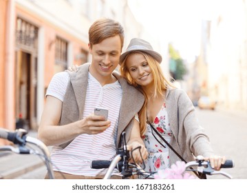 summer holidays, bikes, love, relationship, navigation, gps and dating concept - couple with bicycles and smartphone in the city - Powered by Shutterstock