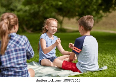 Summer Holidays, Entertainment, Childhood, Leisure And People Concept - Group Of Happy Pre-teen Kids Playing Rock-paper-scissors Game In Park