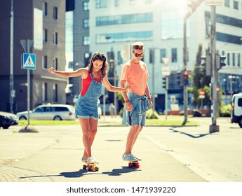 Summer Holidays, Extreme Sport And People Concept - Happy Teenage Couple Riding Short Modern Cruiser Skateboards On City Street