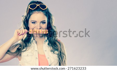 Summer holidays happiness concept. Happy joyful and cheerful young woman female model covering lips with popsicle ice pop cross filter