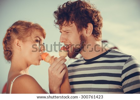 Summer holidays and happiness concept. Young couple eating ice cream outdoor in the city
