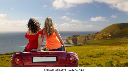 Summer Holidays, Road Trip And Travel Concept - Happy Friends Driving In Convertible Car Over Big Sur Coast Of California Background