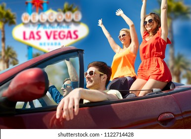 Summer Holidays, Road Trip And Travel Concept - Happy Friends Driving In Convertible Car And Waving Hands Over Welcome To Fabulous Las Vegas Sign Background