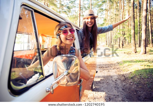 summer holidays,\
road trip, vacation, travel and people concept - Hipster friends on\
road trip on a summers\
day