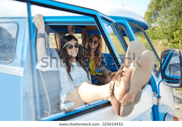 summer\
holidays, road trip, vacation, travel and people concept - smiling\
young hippie women resting in minivan\
car