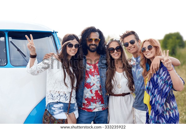 summer holidays,
road trip, vacation, travel and people concept - smiling young
hippie friends over minivan
car