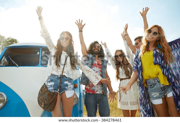 summer
holidays, road trip, vacation, travel and people concept - smiling
young hippie friends having fun over minivan
car