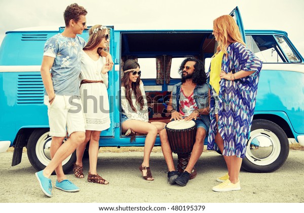 summer holidays, road trip, vacation, travel and\
people concept - happy young hippie friends with tom-tom drum\
playing music over minivan\
car