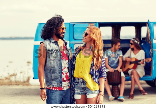 summer\
holidays, road trip, vacation, travel and people concept - smiling\
young hippie couple talking over minivan\
car