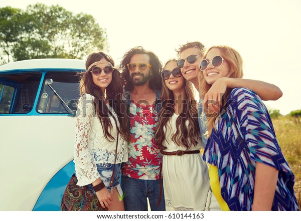 summer holidays,\
road trip, vacation, travel and people concept - smiling young\
hippie friends over minivan\
car