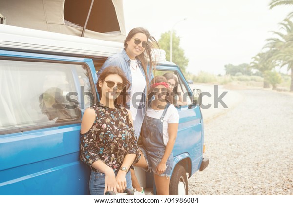 Summer holidays, road trip,\
vacation, travel and people concept - smiling young hippie women in\
car