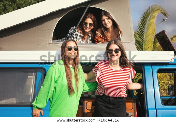 Summer holidays, road trip,\
vacation, travel and people concept - smiling young hippie women in\
car