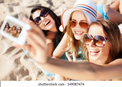 summer holidays, technology and beach concept - girls taking selfie on the beach - Powered by Shutterstock