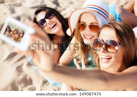 summer holidays, technology and beach concept - girls taking selfie on the beach