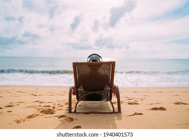 summer holidays, technology and internet concept. latin american man sitting on the beach chair, listen music with headphone and sunning on the beach - Powered by Shutterstock