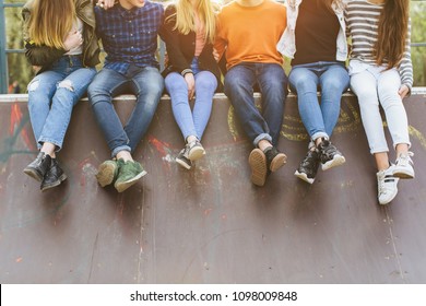 Summer Holidays And Teenage Concept - Group Of Smiling Teenagers With Skateboard Hanging Out Outside.