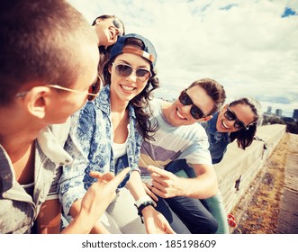 Summer Holidays And Teenage Concept - Group Of Teenagers Hanging Out Outside