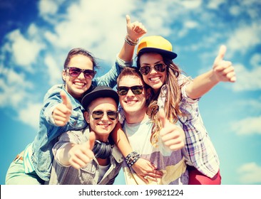 summer holidays and teenage concept - group of smiling teenagers in sunglasses hanging outside and showing thumbs up - Powered by Shutterstock