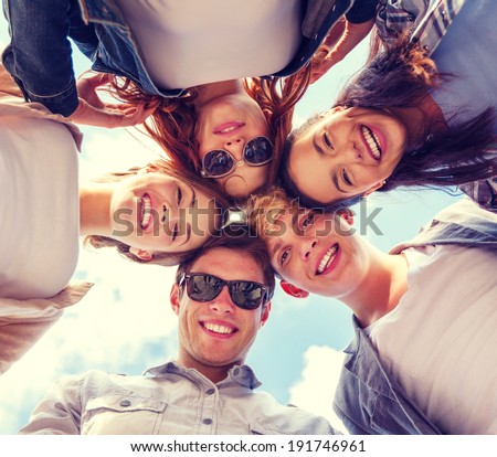 summer holidays and teenage concept - group of teenagers looking down